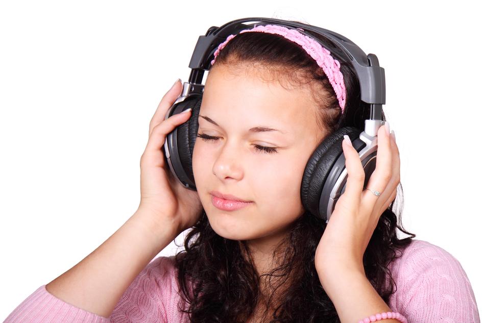 Portrait of the cute girl, with the headphones, listening to headphones, at white background
