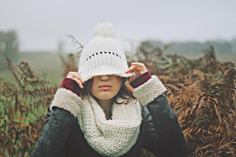 Portrait of the girl with white bonnet, scarf, in jacket, among the colorful plants, in fog, in autumn