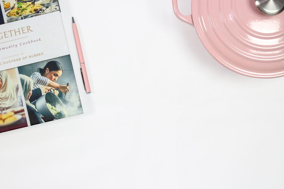 a book with a picture of Meghan Markle near the pink pans