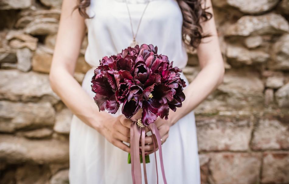 Beautiful and colorful bouquet, with the flowers, in the hands of the girl, in the beautiful, white dress, with the necklace