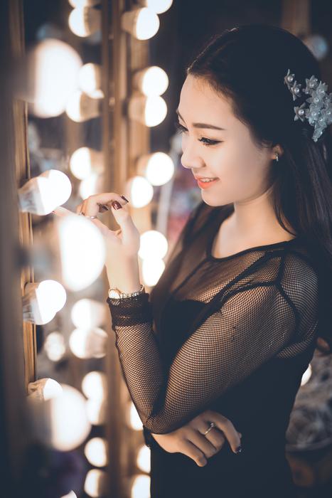 happy girl in black posing in bokeh background