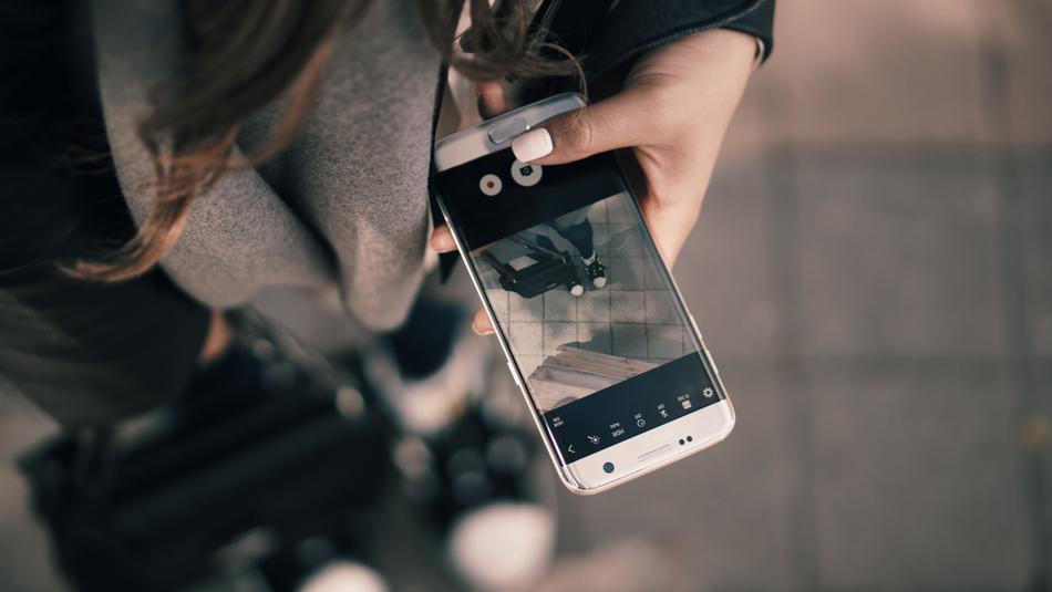 woman with mobile phone in hand in blurred background