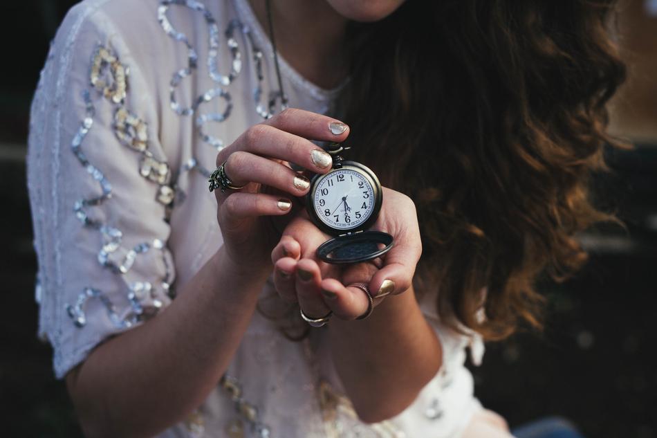 Woman with the wavy hair, in the shiny dress, with the watch,