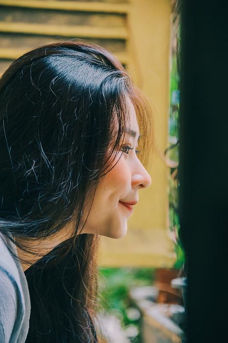 Profile portrait of a smiling woman, looking out of the window