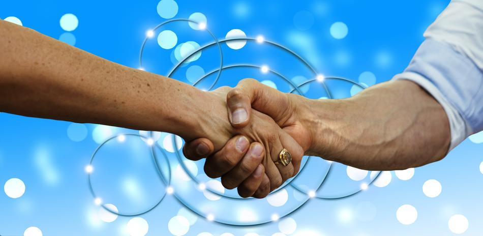 Handshake of two persons at blue background with lights