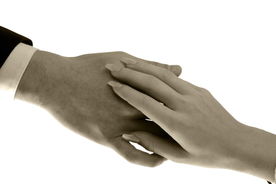 Close-up of the hand contact of the man and woman, at white background