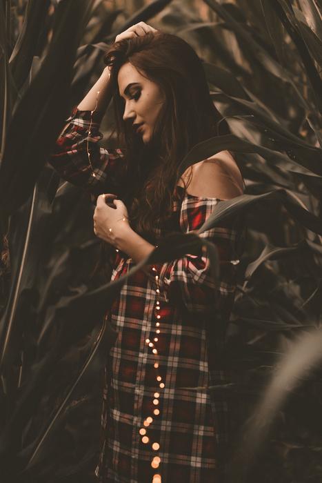 Girl with lights in corn field at dusk