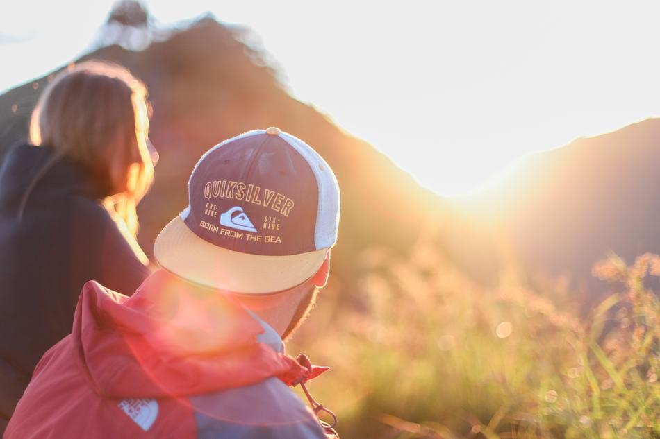 woman and man in the rays of sunlight in the mountains