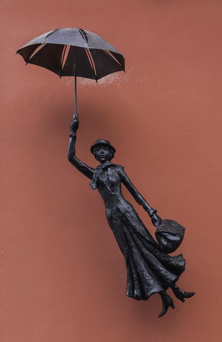 Beautiful, shiny, black figure of the woman, flying with the umbrella