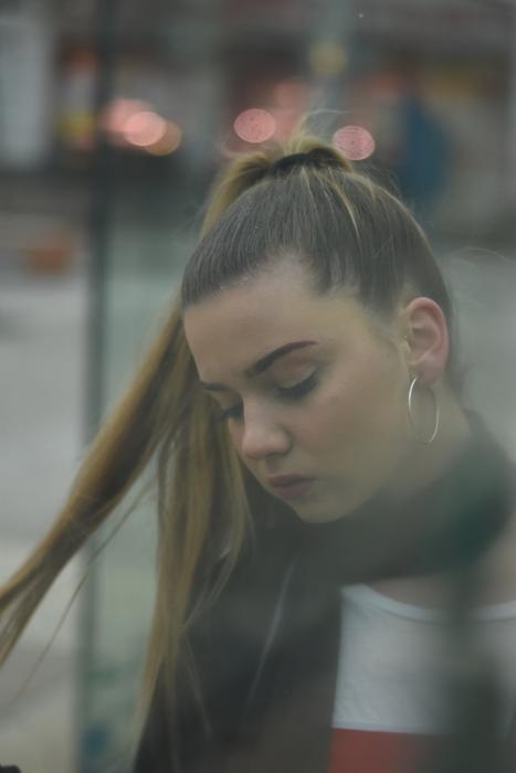 Portrait of the beautiful girl with closed eyes, at background with colorful lights