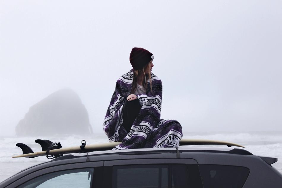 girl is sitting on the roof of the car