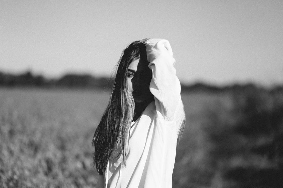 Black and white photo of the beautiful, posing girl on the field
