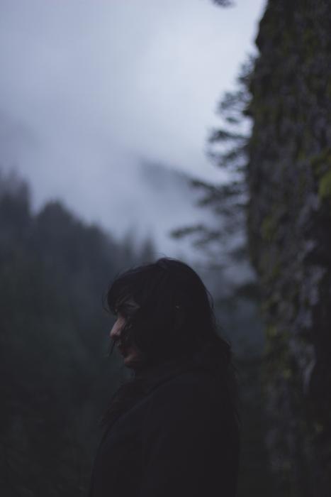 Silhouette of a girl, among the beautiful, foggy forest on the mountains