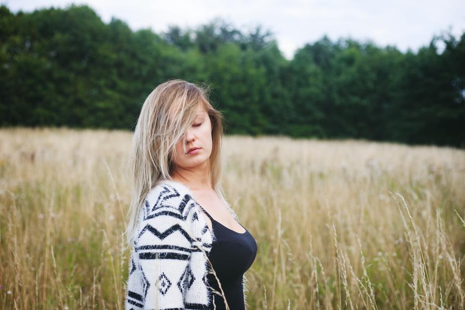 photo of a blonde with closed eyes on a wheat field