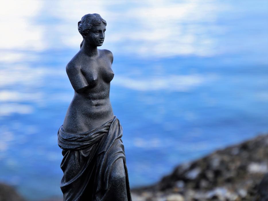Beautiful Venus statue, on the coast with blue water