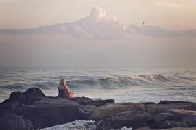 sitting woman on the beach rocks