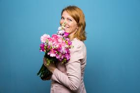 woman with bouquet on blue background