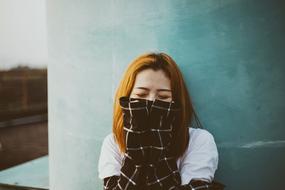 beautiful girl in a plaid jacket near the wall