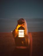 Girl with lantern in hand at dusk