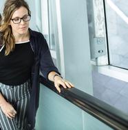 Blonde woman wearing glasses on escalator