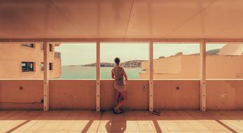 Back view of the person, looking on the beautiful landscape with turquoise water and hills