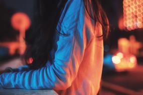 Sitting woman among the colorful lights of the city