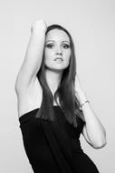 Black and white photo of the woman in black dress, and with the bracelet, posing