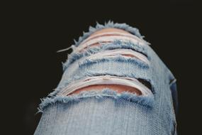 leg in ripped jeans close up