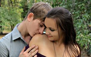 guy kissing girl's shoulder