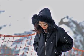 woman in a jacket and sunglasses on the background of the alps