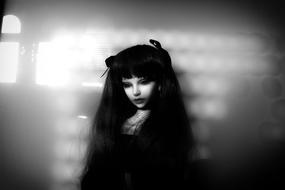 Black and white photo, with the portrait of the girl doll, at background with the lights