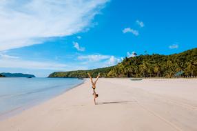 girl standing upside down on a tropical beach
