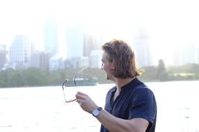 stylish man with glasses on the background of skyscrapers in the haze