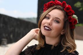 beautiful woman in a wreath of red roses