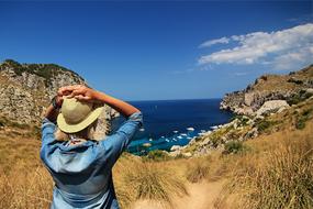 girl in a hat and denim shirt by the ocean