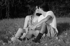 black and white photo of a kissing couple in the meadow