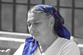 black and white photo of an elderly woman wearing a blue headscarf