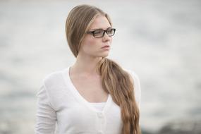 pensive blonde with glasses on a blurred background