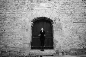 Black And White photo of Human Woman near door