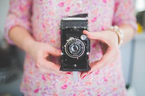 Camera Old Vintage in hands on a blurred background