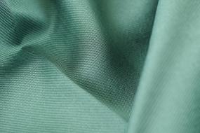 Close-up of the green textile fabric, with the shadows