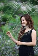 beautiful asian woman in tall grass on a blurred background