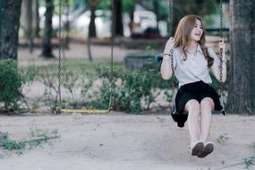 girl riding a swing on the street