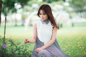 girl posing on a flower meadow on a blurred background