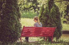 blonde on a red park bench