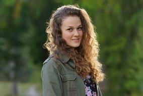 beautiful girl with curly hair on a blurred background