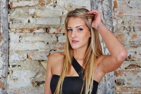 beautiful blonde long hair woman at old brick wall