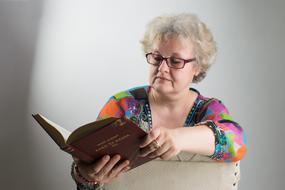 woman reading a book with glasses