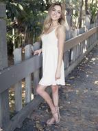 Smiling Beautiful slim Girl at wooden fence