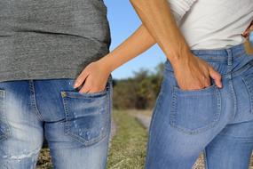 Woman and man with hands in jeans pants pockets